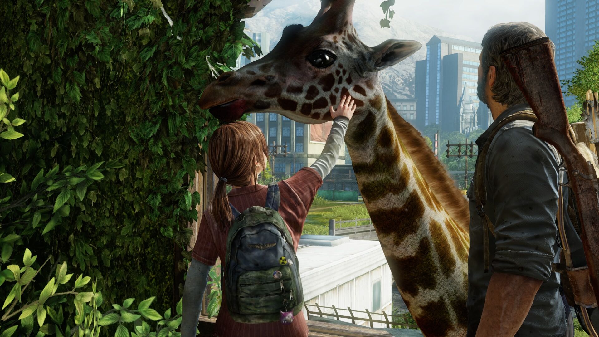 A young girl in a red shirt with a backpack gently touches the head of a giraffe.  A man with a rifle stands behind the giraffe with a city and mountains in the background.